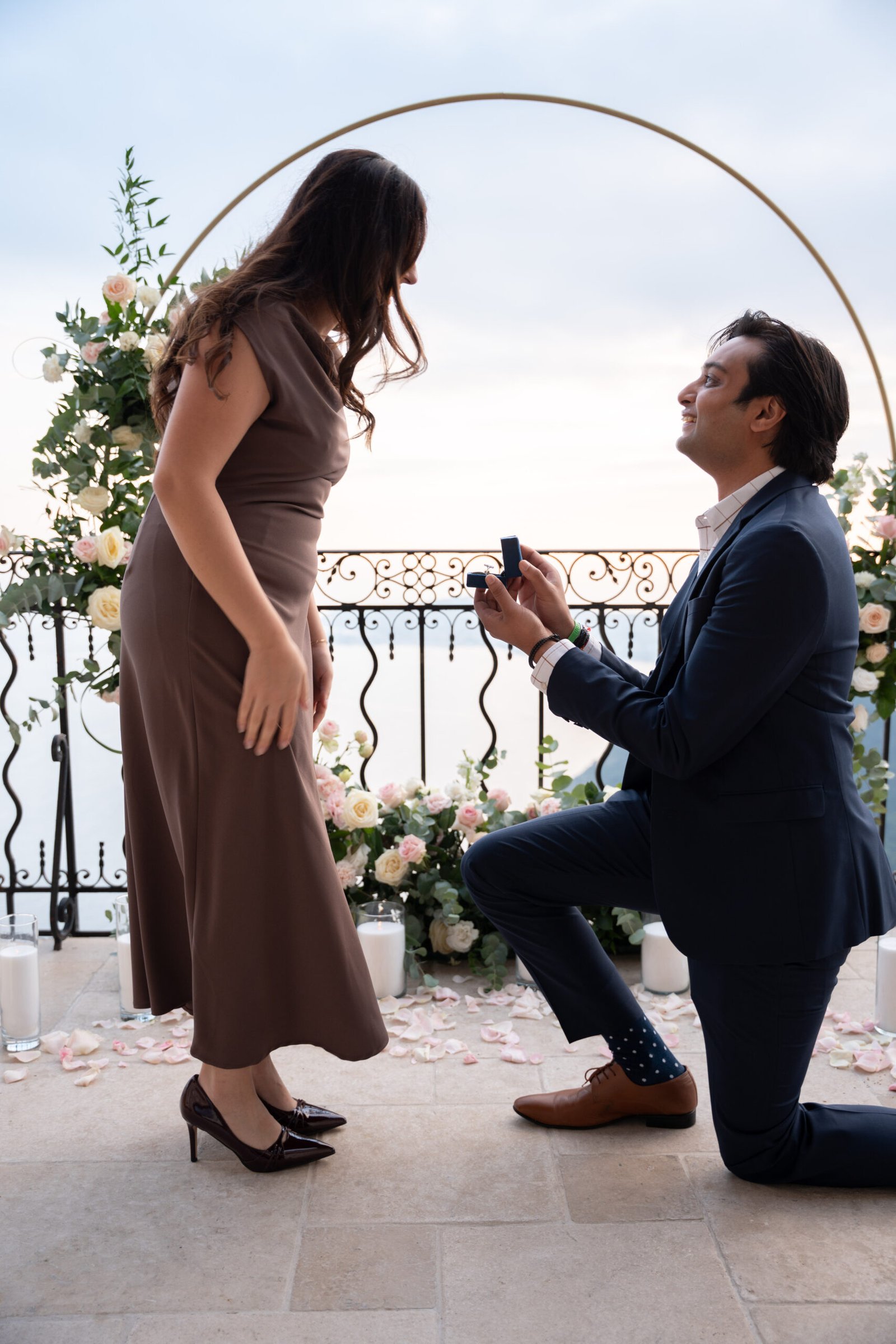 Luxury marriage proposal at Château Eza in Èze on the French Riviera with elegant floral arch overlooking the Mediterranean sea.