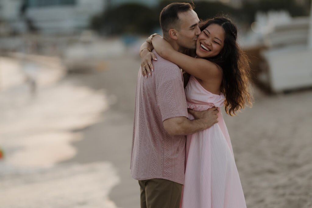 Emotional couple embracing on a beach during a luxury marriage proposal on the French Riviera